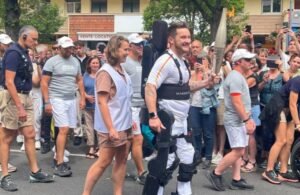 Kevin Piette carries the Olympic torch in Paris wearing a Wandercraft Personal Exoskeleton in July 2024.