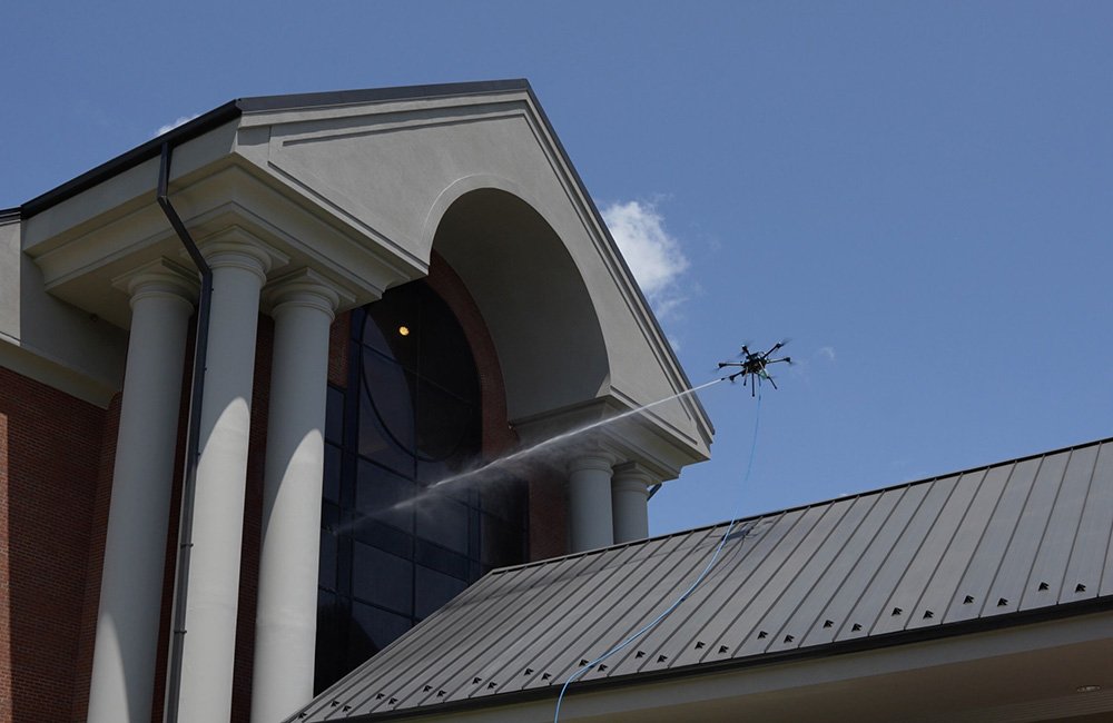 A drone spraying water at the window of a school. 