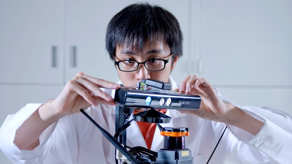 A photo of a man looking at a sensor.