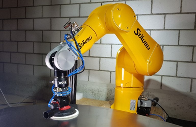 A yellow collaborative robot from Staubli with a Bota force torque sensor attached to the end. 