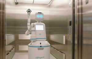 A 'humanoid for hospitals,' Moxi has an arm for opening doors and operating elevators. It reached 100k elevator rides in November 2024.