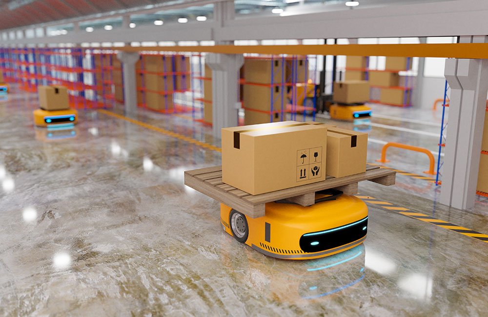 A yellow mobile robot carrying a pallet with two cardboard boxes driving through a warehouse on marble floors. Trailing it is another mobile robot. 