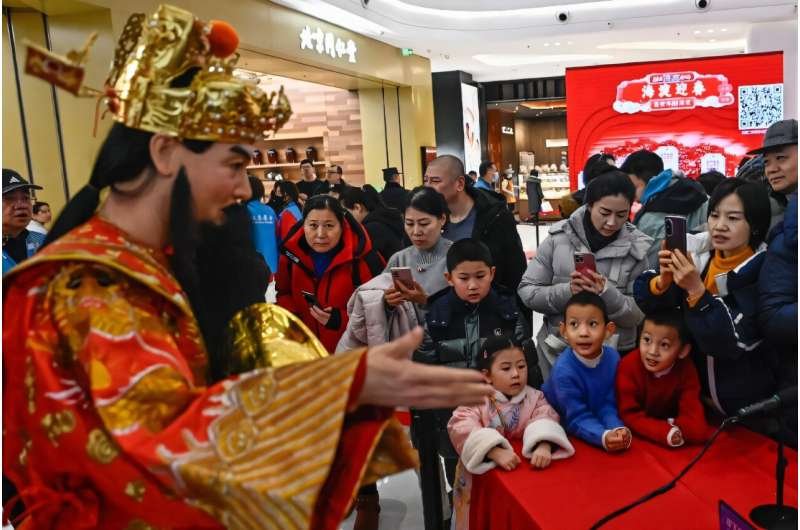 A humanoid robotic in passe Chinese language costume answers questions at an AI-themed temple energetic in Beijing