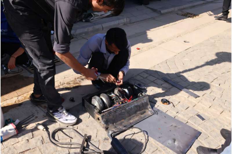 Engineering students prepare their robot for a fight match at Iran's Tech Olympics